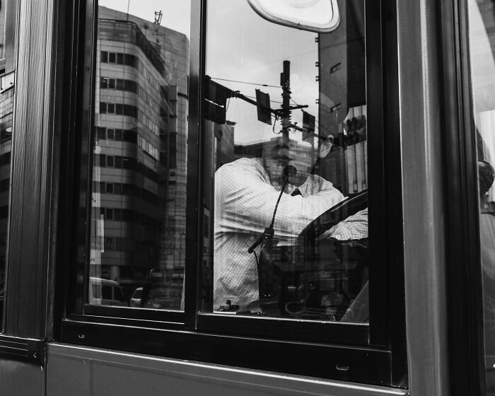 Man inside a Tokyo bus, reflecting the fast-paced life in the city.