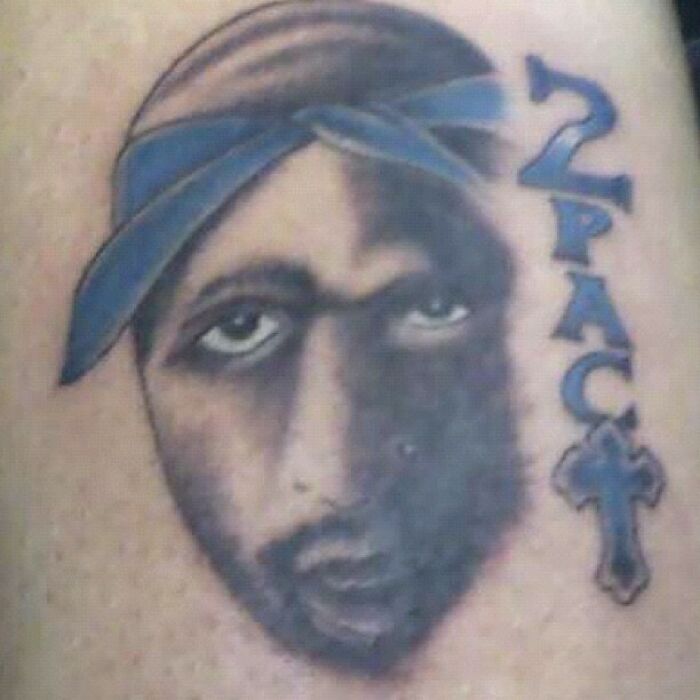 Badly drawn tattoo of a celebrity with "2PAC" and blue bandana; a funny tattoo fail.
