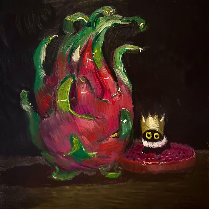 Chaotic black cat with crown next to a colorful abstract dragon fruit painting.