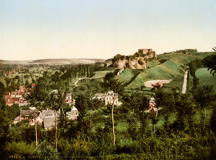 Oldest color photo of a lush landscape with a castle on a hill, surrounded by trees and village, showing 100-year-old scenery.