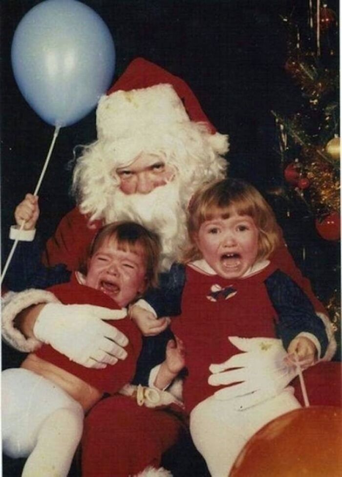 Two kids crying next to a creepy Santa holding a balloon.