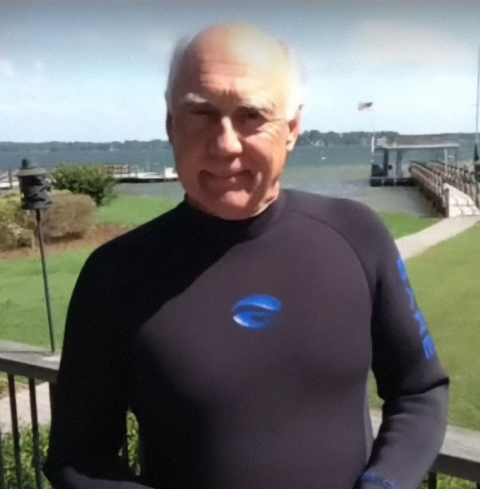Dixon Handshaw wearing a wetsuit outdoors near water, smiling after reuniting with family.