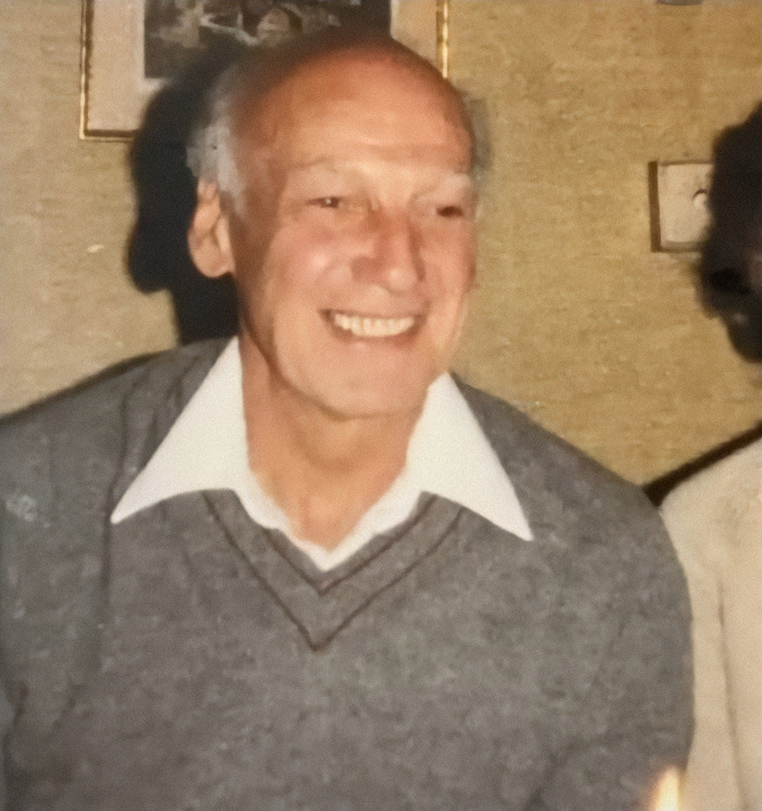 Elderly man smiling warmly, symbolizing reunion with his family after 75 years.