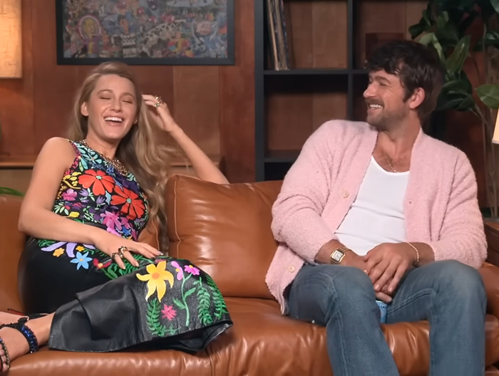 Blake Lively and co-star on a couch, sharing a laugh during an interview. Blake Lively and co-star on a couch, sharing a laugh during an interview.