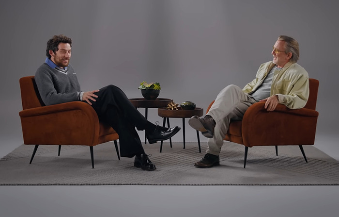 Daniel Craig and Josh O'Connor in armchairs having a casual conversation on set, discussing filming experiences.