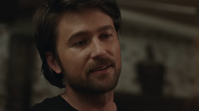 Brandon Sklenar in a dimly lit room, looking thoughtful and expressive in a scene from "It Ends With Us. Brandon Sklenar in a dimly lit room, looking thoughtful and expressive in a scene from "It Ends With Us.