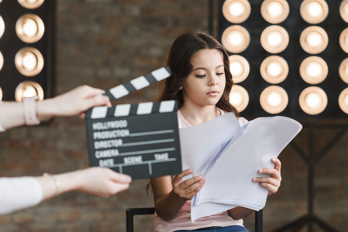 Young actress reviewing script during audition, highlighting non-famous actress reality.
