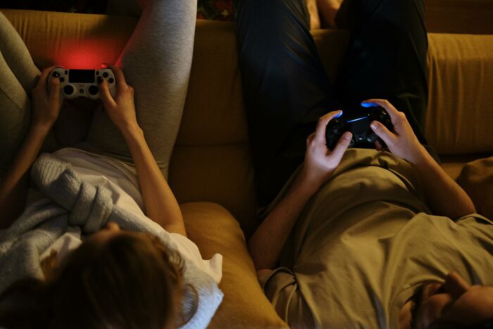 Two people on a couch playing video games, illustrating a relaxed leisure activity, representing bad-good-habit theme.