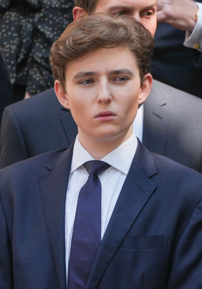 Young man in a suit at a formal event, relating to Barron Trump's girlfriend rumors.