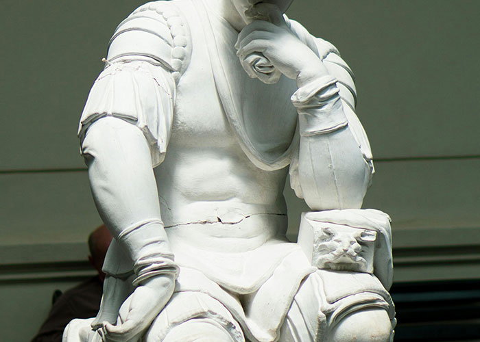 A detailed white stone statue with intricate armor in someone’s home.