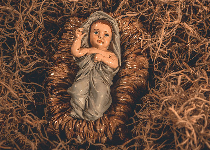 Baby figurine in a nest of straw, surprising discovery in someone's home.
