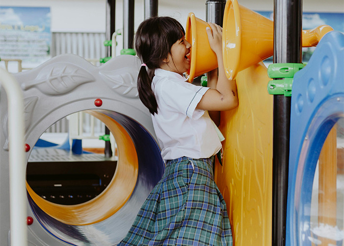 Girl playing on a playground with a surprised expression, highlighting a shocking element in someone else's home setting.