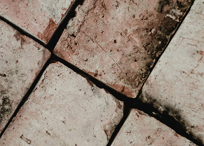 Close-up of worn bricks arranged in a unique pattern in someone's home.