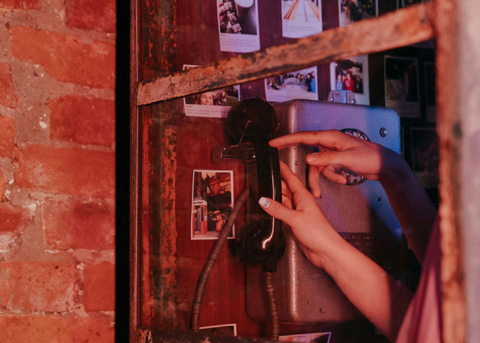 Vintage phone in a rustic home setting, surrounded by polaroid photos, showing unique home decor.