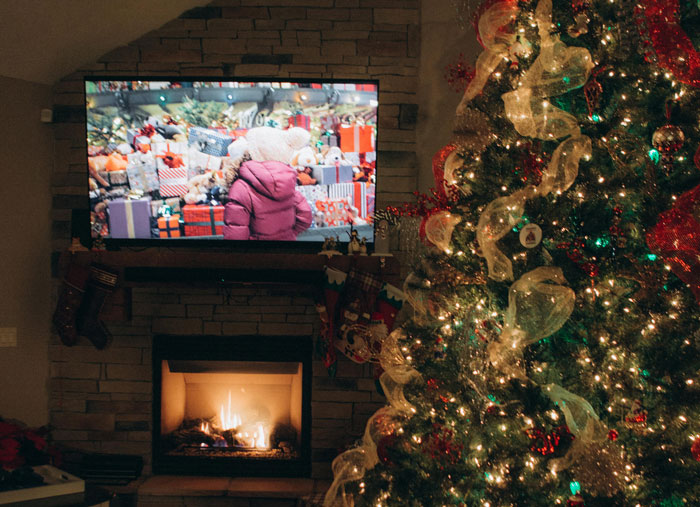 "Christmas tree and fireplace with a TV showing a scene from a Rocky movie, creating a festive brotherly atmosphere. "Christmas tree and fireplace with a TV showing a scene from a Rocky movie, creating a festive brotherly atmosphere.