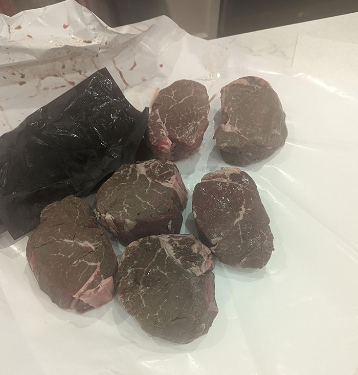 Close-up of raw steaks on butcher paper, representing a Christmas accident with packaged meat.