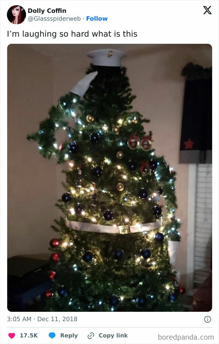 Christmas tree decorated with lights and ornaments, topped with a hat, creatively resembling a person.