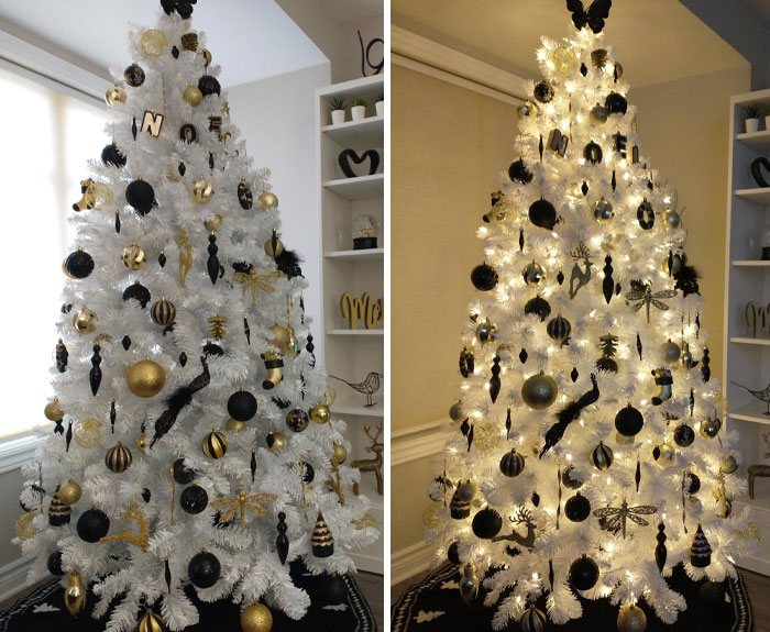 White Christmas tree with black and gold ornaments, beautifully decorated in a cozy living room.