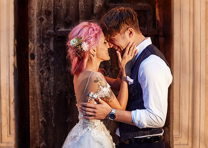 A couple in wedding attire shares a tender moment, highlighting a change in perception of their relationship.