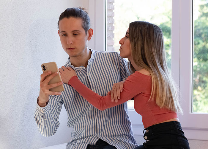 Couple experiencing a moment of tension over a phone message, highlighting changes in partner perception.