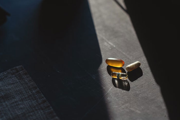 Vitamins on a dark surface, representing crazy body life hacks for health and wellness.