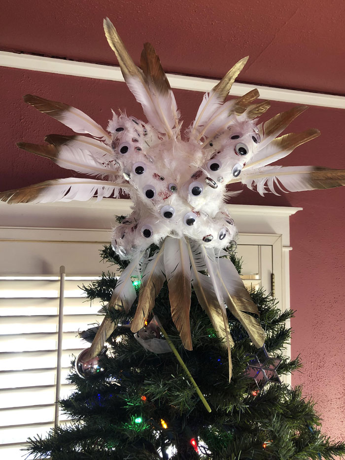 Creative DIY Christmas decoration with feathers and googly eyes as a unique tree topper.