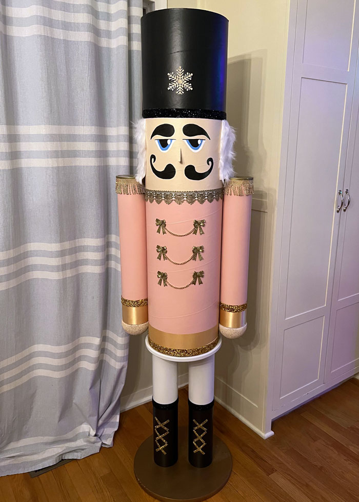 DIY nutcracker decoration made from cardboard tubes, featuring pink and gold details, great for creative Christmas decorations.