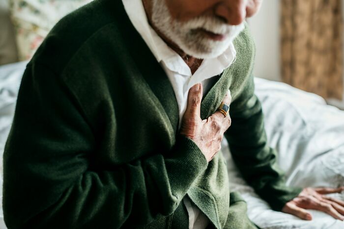 An elderly man clutching his chest, possibly depicting heart health myths.