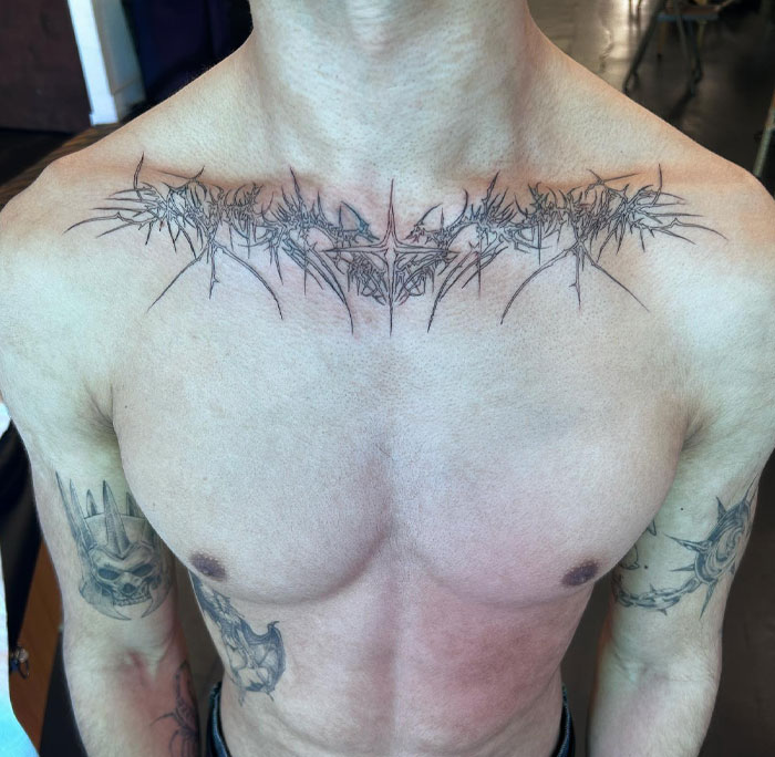 A detailed chest tattoo featuring cybersigilism-inspired symbolism and intricate design elements.