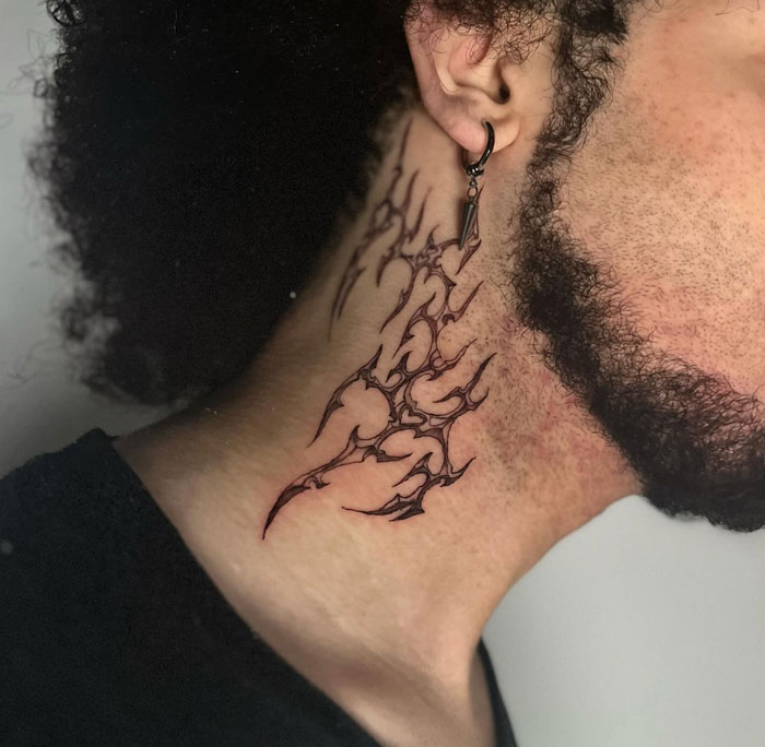 Ornate neck tattoo depicting cybersigilism with intricate tribal design elements.