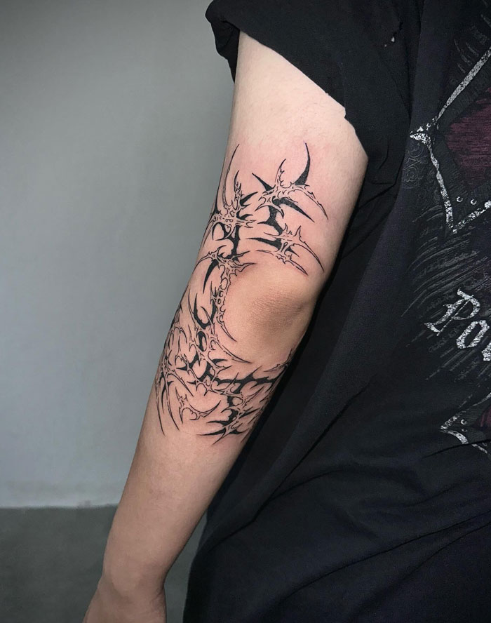 Arm tattoo with intricate cybersigilism design, showcasing unique symbolism and style on a person’s forearm.