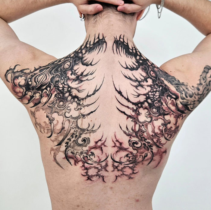 Back tattoo featuring complex cybersigilism design with intricate symbolism and style.