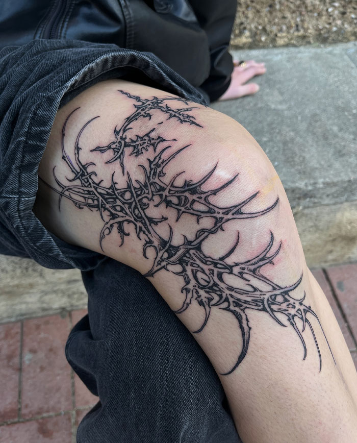 Cybersigilism tattoo with intricate, symbolic design on a person's leg, showcasing creative style and detailed art.