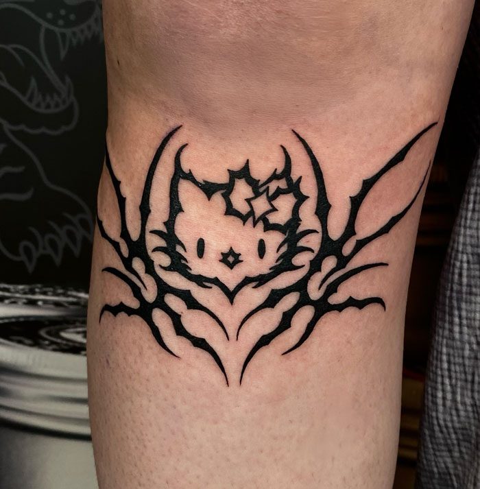 Tattoo featuring cybersigilism design with intricate symbolism and bold lines on a person's arm.