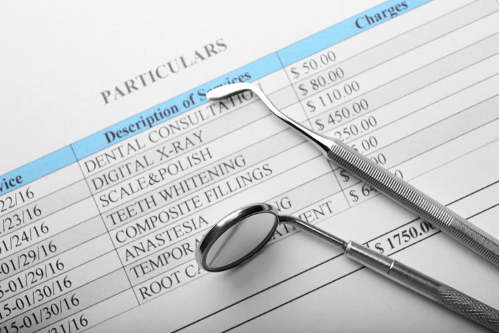 Dental insurance breakdown with treatment costs, dental mirror, and scaler on invoice.