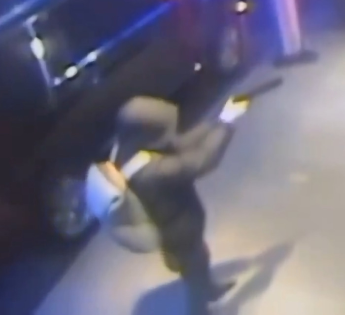 Footage of UnitedHealthcare CEO Brian Thompson's assassin in dim lighting, wearing dark clothing with a backpack. Footage of UnitedHealthcare CEO Brian Thompson's assassin in dim lighting, wearing dark clothing with a backpack.