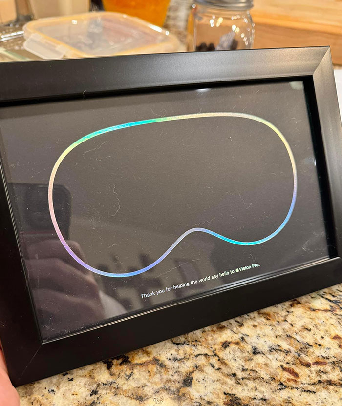 Framed holographic card representing a disappointing gift on a kitchen counter.