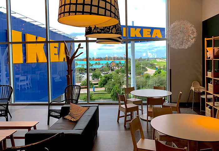 IKEA showroom interior featuring stylish furniture and large windows overlooking greenery.