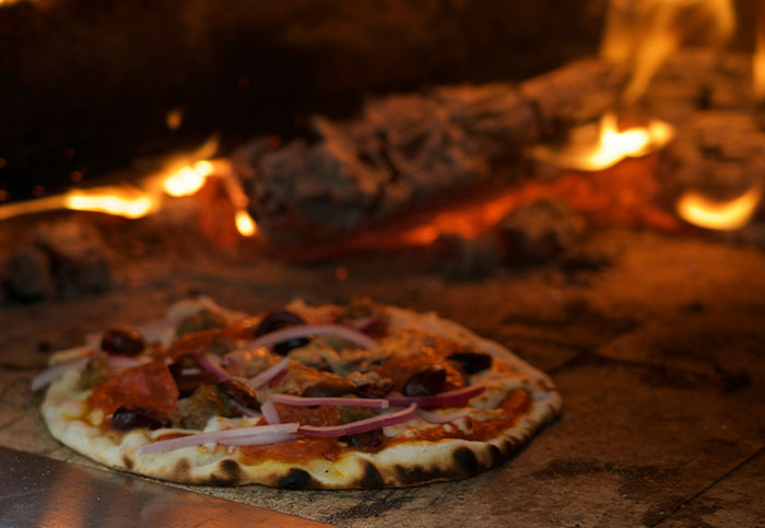 Pizza cooking in a wood-fired oven.
