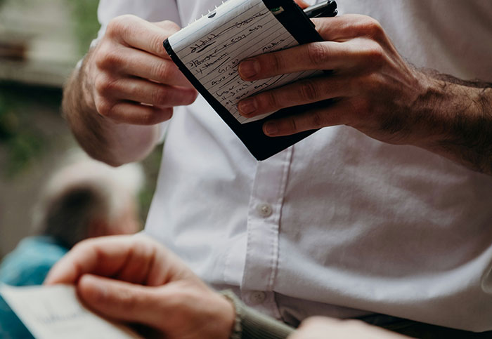Waiter writing on a notepad, capturing a customer's dumb question.