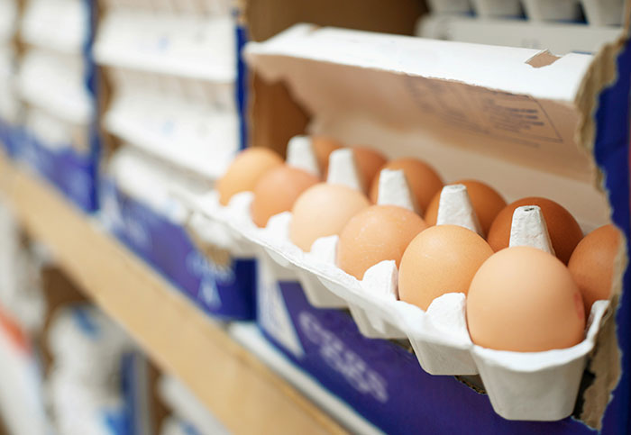 Egg carton on a store shelf, open with brown eggs neatly arranged, related to customer interaction insights.