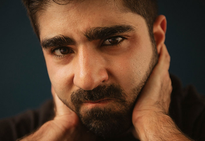 Man with a thoughtful expression holding his neck, related to customer interactions story.