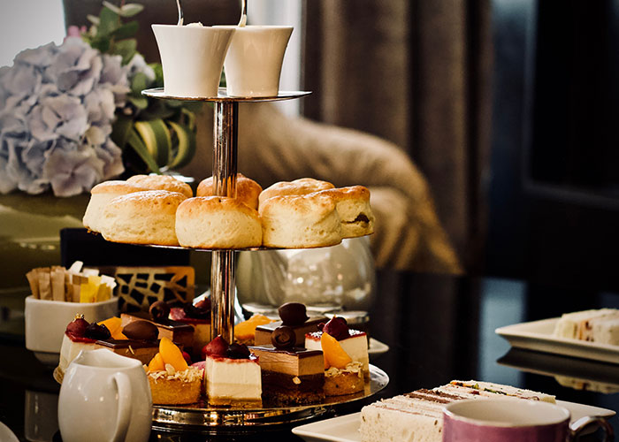 Afternoon tea set with scones and pastries, highlighting indulgence amidst fat-shaming discussions. Afternoon tea set with scones and pastries, highlighting indulgence amidst fat-shaming discussions.