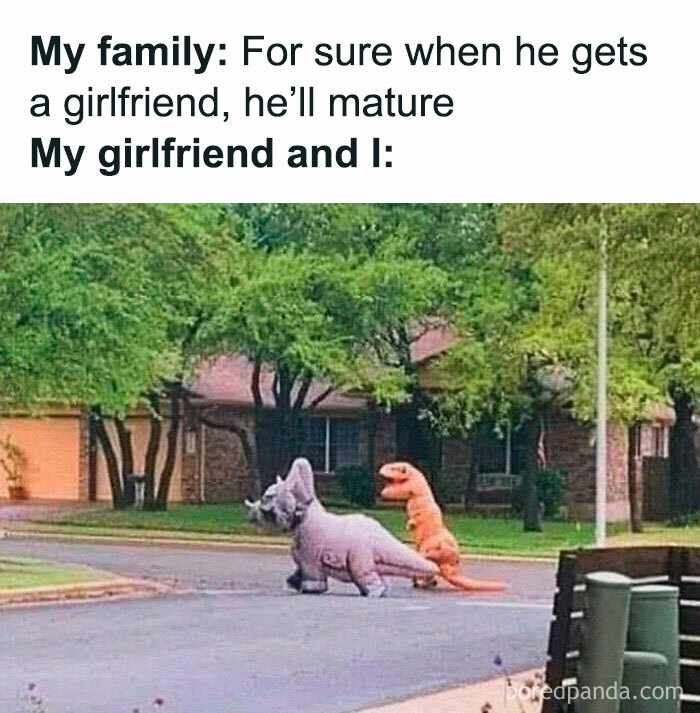 Two people in dinosaur costumes on a street, depicting a humorous scene for those with a prehistoric sense of humor.