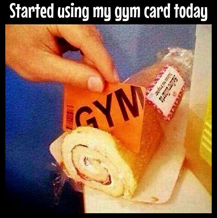 Hand holding a gym card in front of a Swiss roll, humorously portraying dieting frustrations.