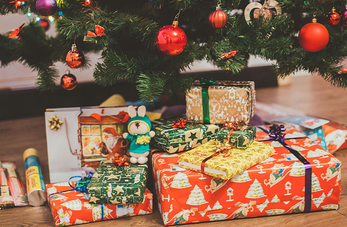 Gifts wrapped in festive paper under a decorated Christmas tree, highlighting holiday surprises and family gatherings.