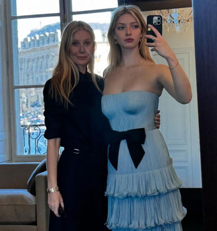 Apple Martin and mom Gwyneth Paltrow posing for a mirror selfie, one in a strapless blue dress.