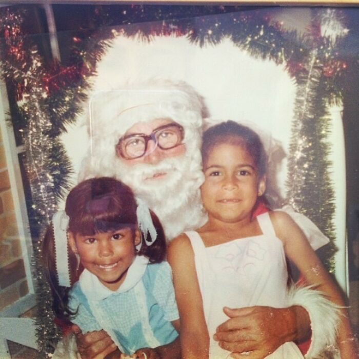 Creepy-Santas with glasses posing with two smiling children in festive setting.
