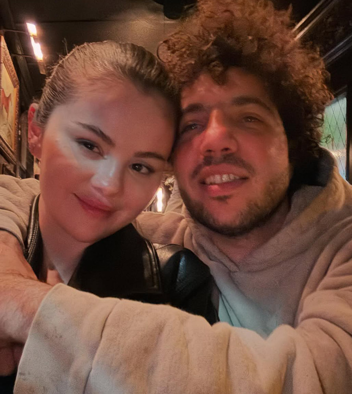 Selena Gomez and Benny Blanco in a cozy setting, sitting closely in dimly lit surroundings. Selena Gomez and Benny Blanco in a cozy setting, sitting closely in dimly lit surroundings.