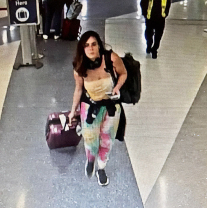 Woman with luggage at airport, wearing colorful pants and a backpack, embodies focus on healing journey. Woman with luggage at airport, wearing colorful pants and a backpack, embodies focus on healing journey.